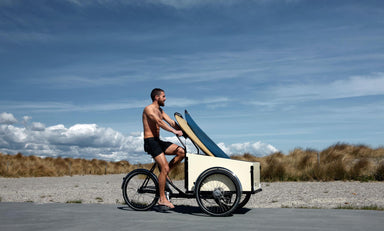 man riding a bike with surf boards