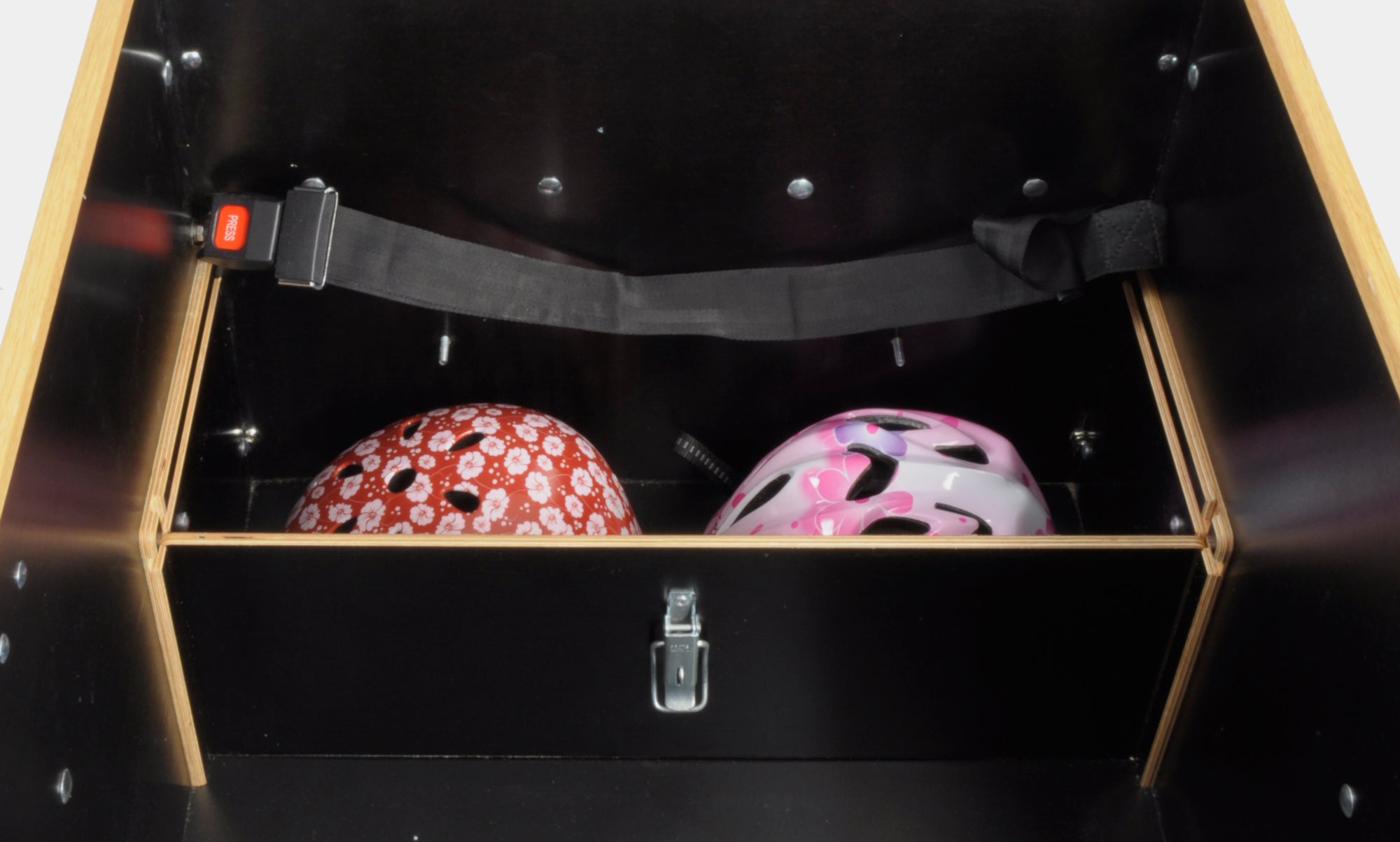 Interior view of the cargo box in the Classic Sloped midDrive Pro I5 by Christiania Bikes America, featuring space for two helmets with a safety strap.
