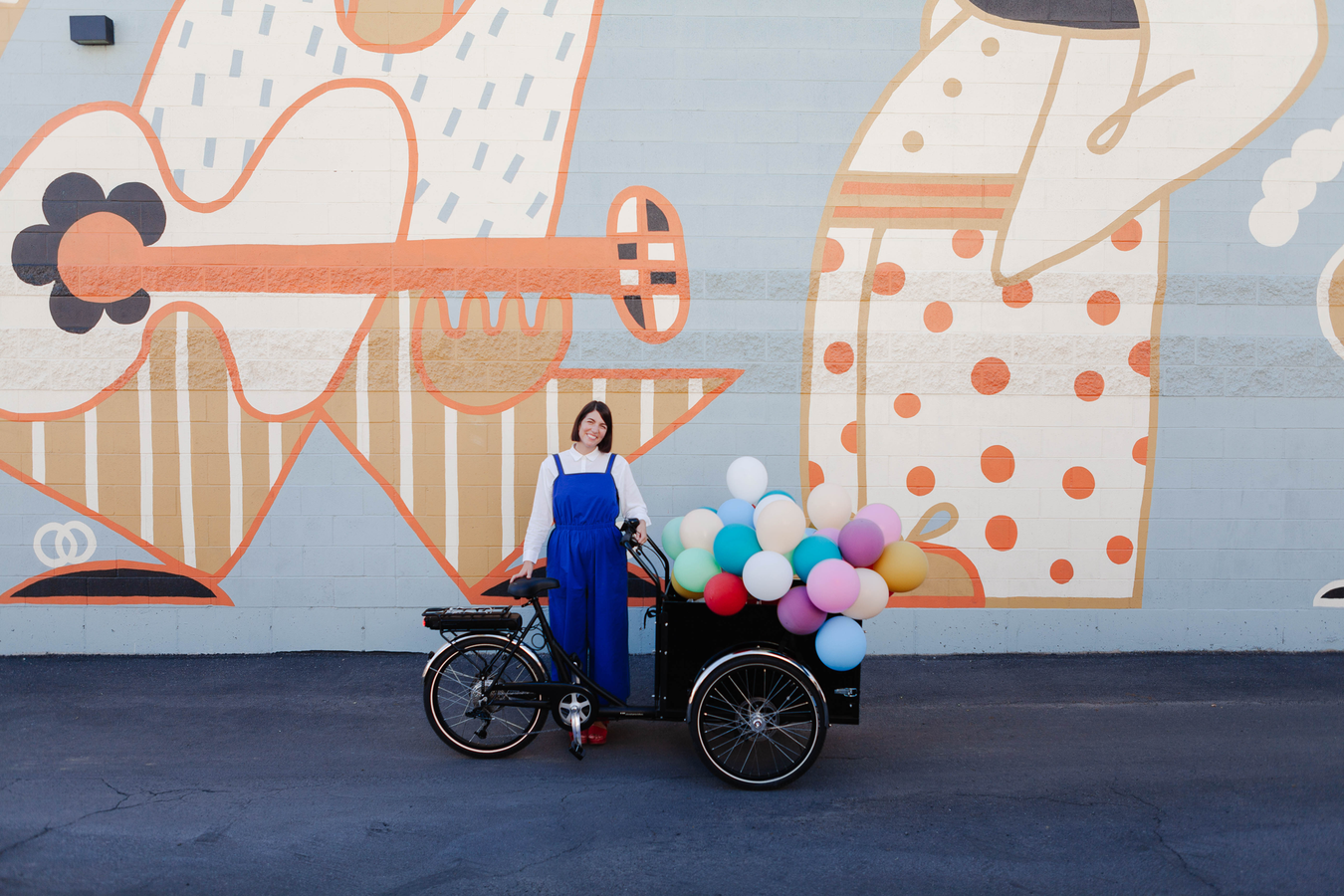 woman on a cargo bike with balloons